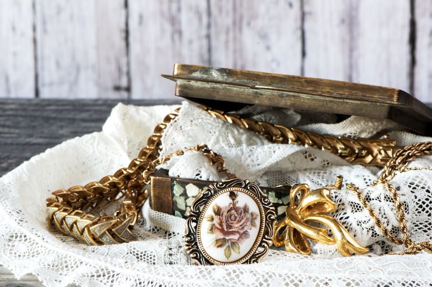 a box of antique jewelry set on lace